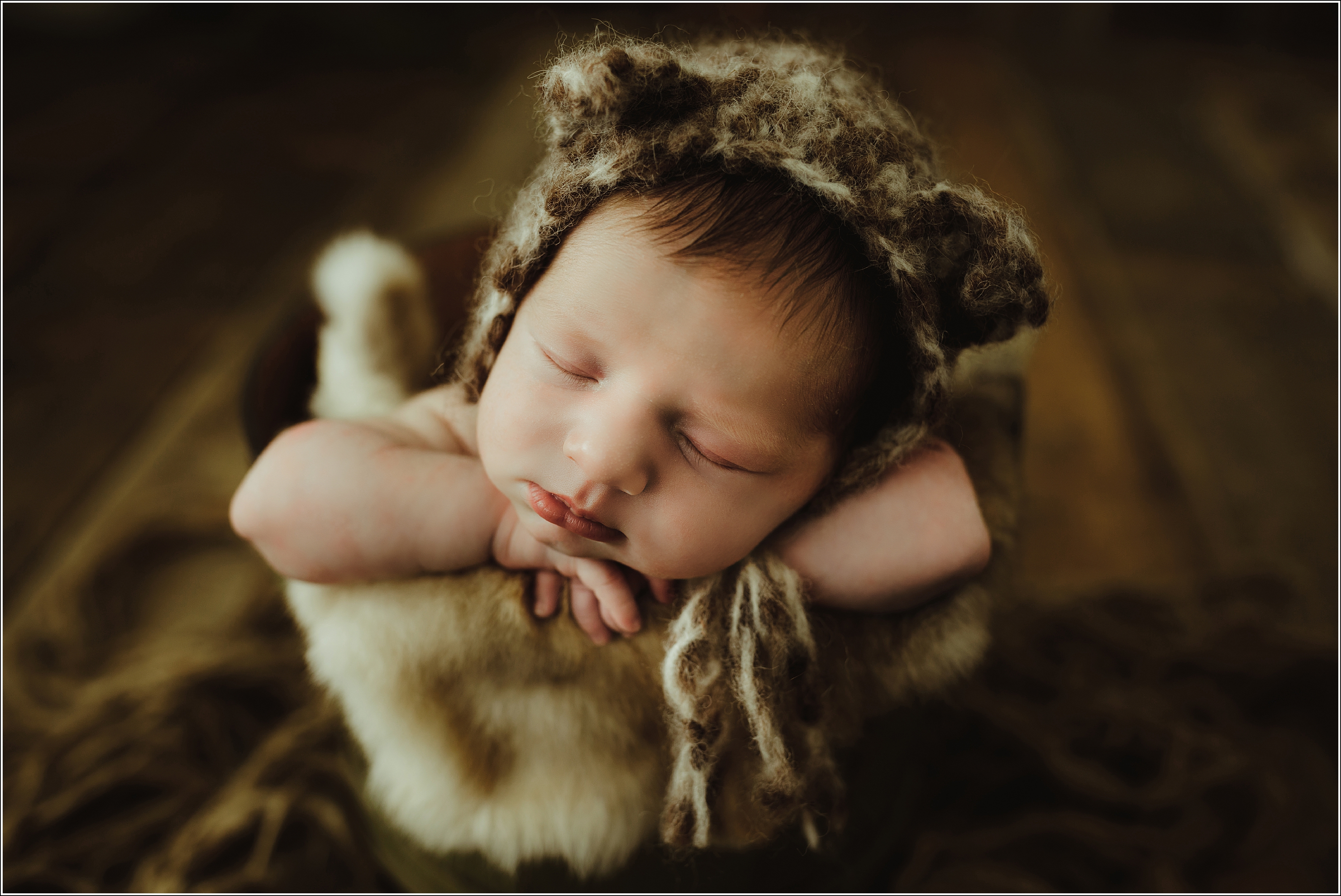 newborn boy portrait sleeping in a bucket with fur and brown bonnet La Crosse WI Rochester MN Winona, MN