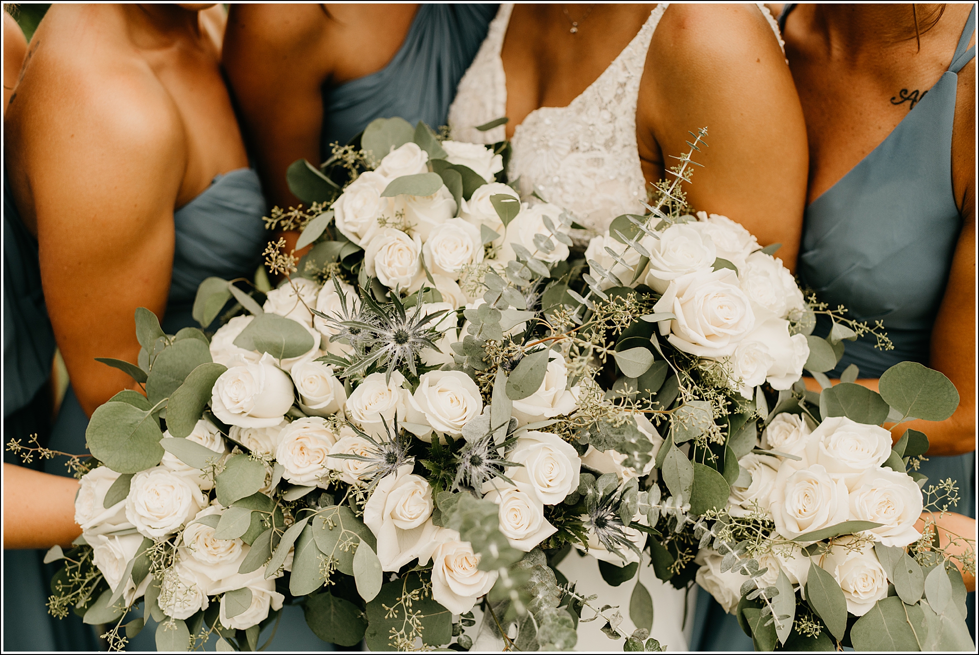La Crosse wedding photographer bouquets white roses flowers eucalyptus greens bridesmaids holding snuggled together 