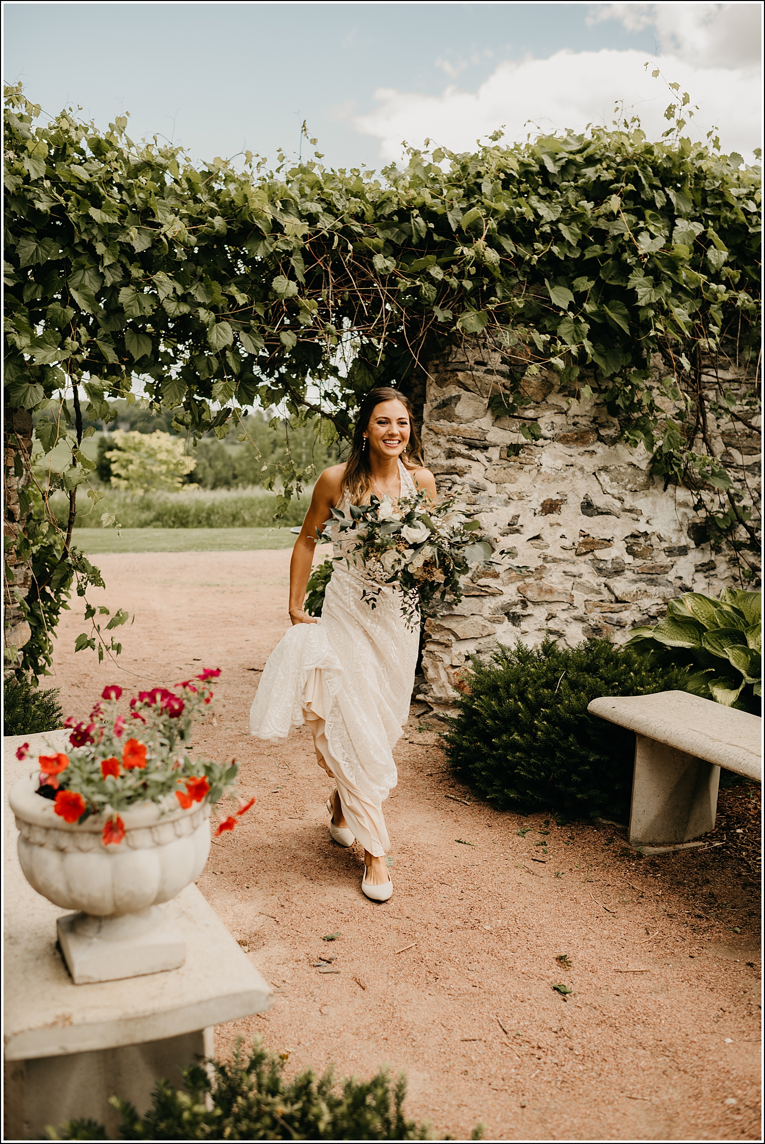 Tansy hill farm wisconsin wedding photographer bride smiling walking in garden vines rock wall